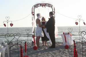 Wedding Arch With Red Accents On The Beach